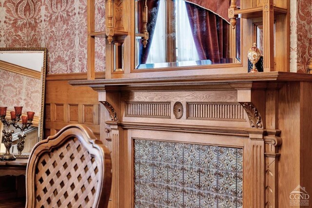 dining space with wood walls, wood-type flooring, ornamental molding, and a chandelier