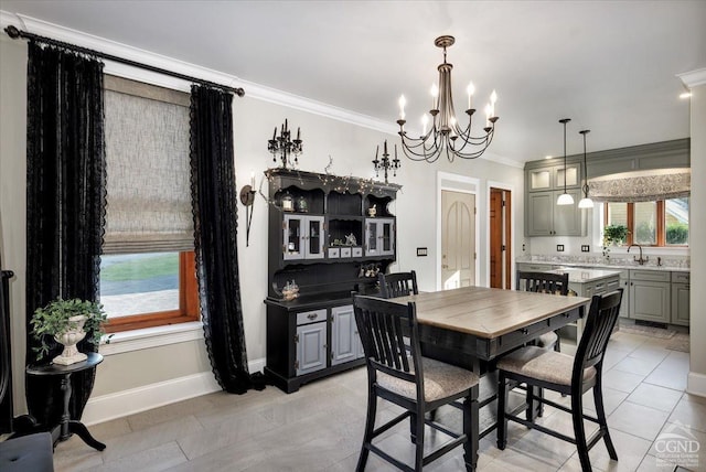 tiled dining space with a chandelier, crown molding, and sink