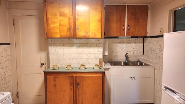 kitchen featuring decorative backsplash, white cabinetry, sink, and white refrigerator