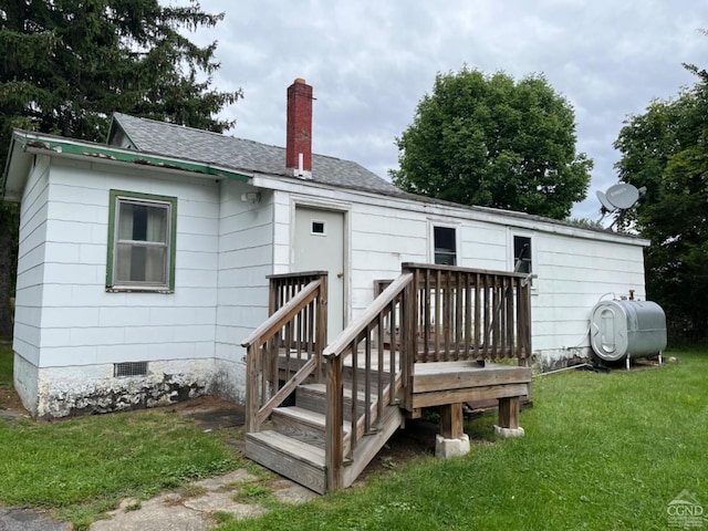 back of house featuring a deck and a lawn