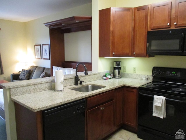 kitchen featuring light stone counters, sink, black appliances, and kitchen peninsula