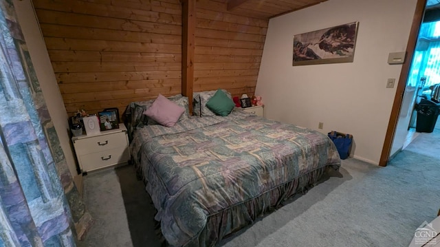 carpeted bedroom with wooden walls and wooden ceiling