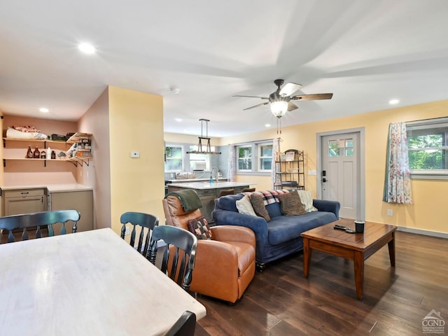 living room featuring ceiling fan, sink, and dark wood-type flooring