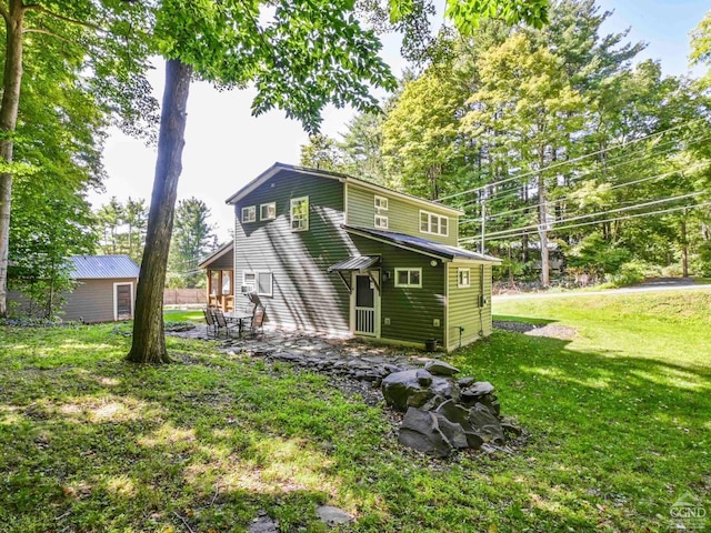 rear view of house with a lawn and a patio