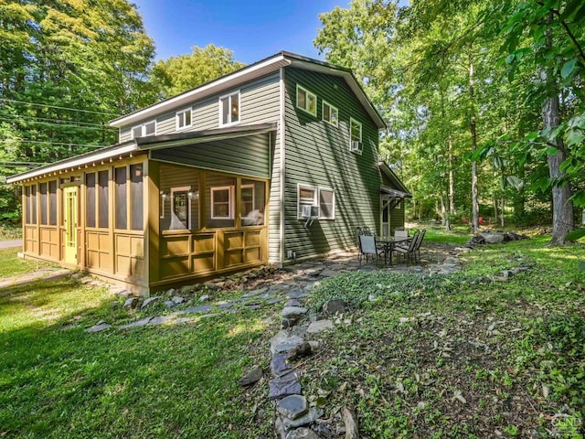 view of home's exterior with a patio area, a sunroom, and a yard