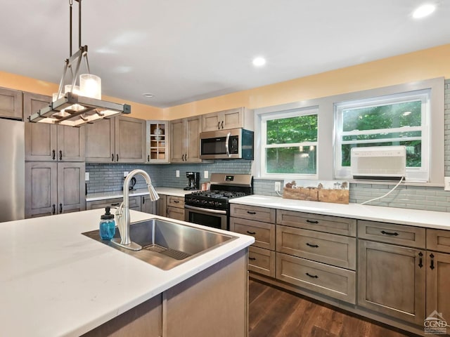 kitchen featuring appliances with stainless steel finishes, dark hardwood / wood-style flooring, a wealth of natural light, and sink