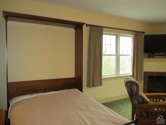 bedroom featuring a tiled fireplace