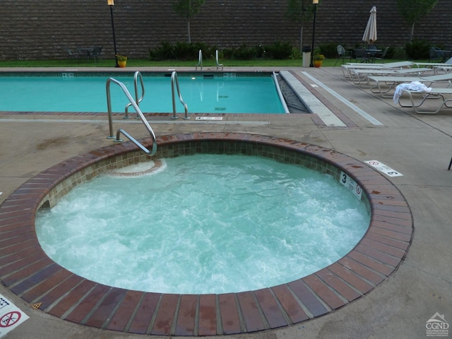 view of pool with a patio and a community hot tub