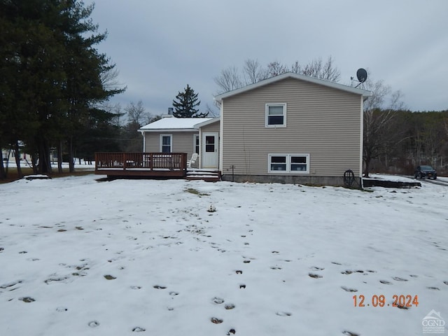 snow covered rear of property featuring a wooden deck