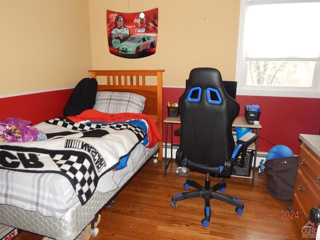 bedroom featuring hardwood / wood-style floors and a baseboard radiator