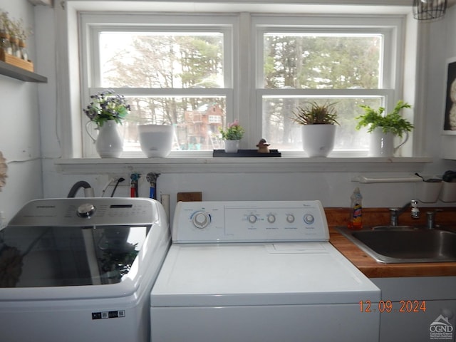 laundry area with separate washer and dryer and sink