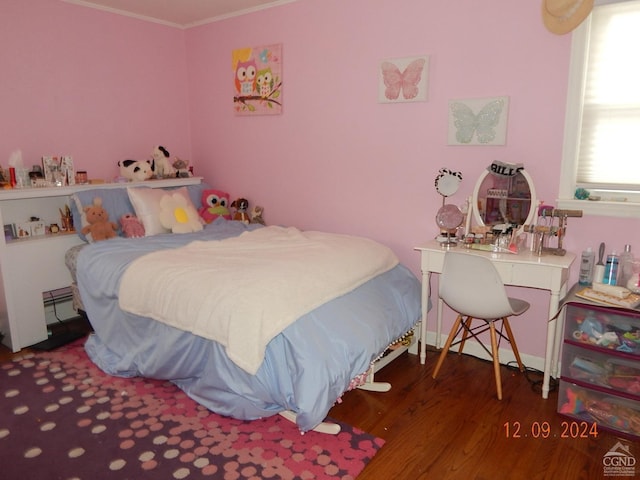 bedroom with baseboard heating, crown molding, and dark wood-type flooring