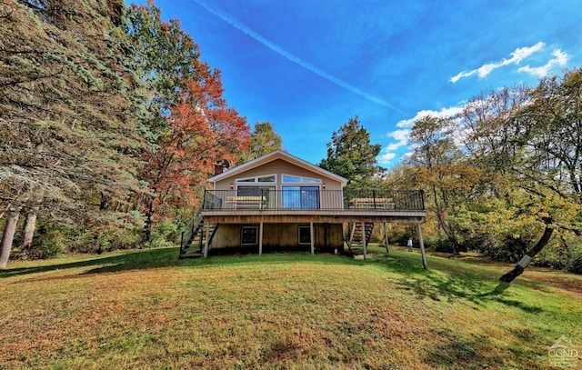 rear view of house with a wooden deck and a yard