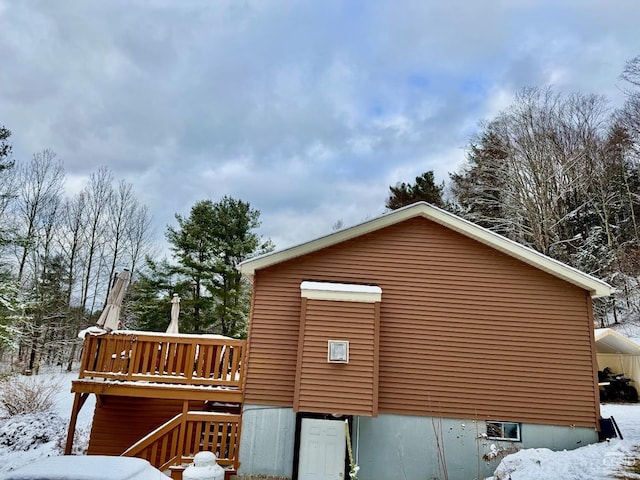 view of snowy exterior featuring a deck