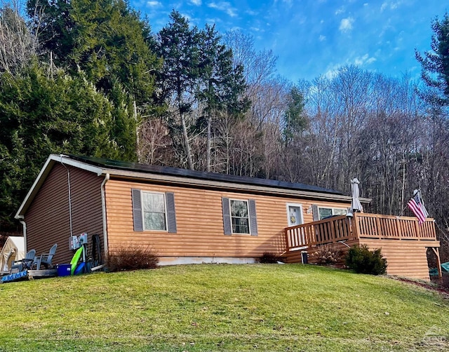 back of house with a lawn and a deck