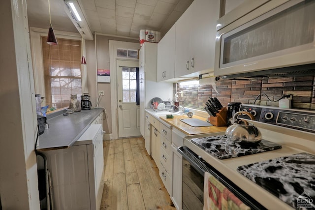 kitchen featuring tasteful backsplash, light hardwood / wood-style flooring, white cabinets, and electric range oven