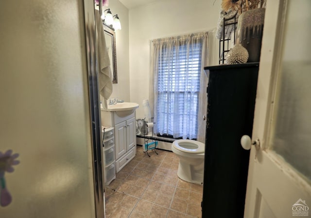 bathroom featuring baseboard heating, a shower with door, vanity, and toilet