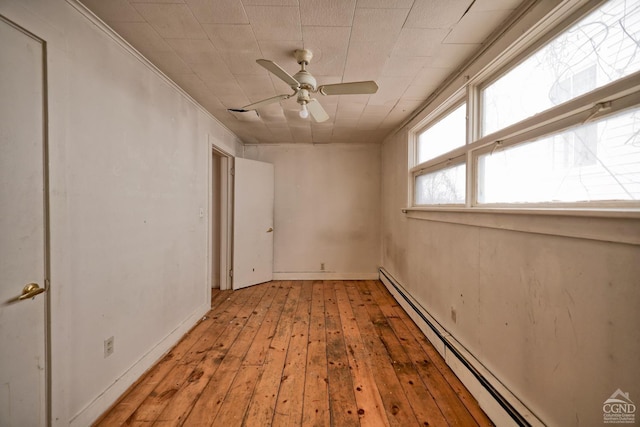 empty room featuring crown molding, ceiling fan, light hardwood / wood-style flooring, and a baseboard radiator