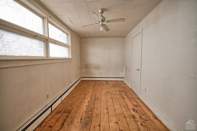 unfurnished room with baseboard heating, ceiling fan, light hardwood / wood-style floors, and ornamental molding