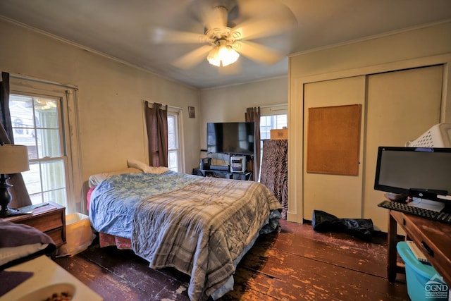 bedroom with ceiling fan, dark hardwood / wood-style flooring, ornamental molding, and a closet