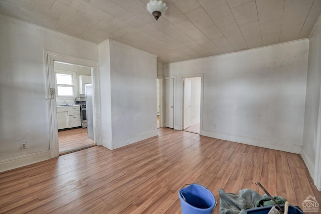 empty room featuring light hardwood / wood-style floors and crown molding