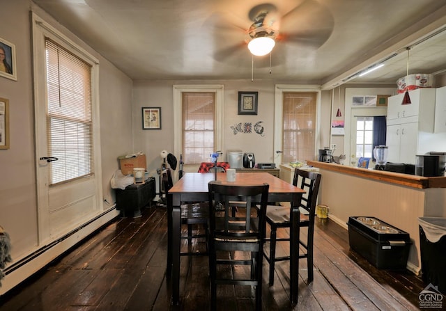 dining room featuring dark hardwood / wood-style floors, a healthy amount of sunlight, baseboard heating, and ceiling fan