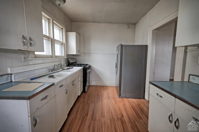 kitchen with white cabinetry, hardwood / wood-style flooring, and appliances with stainless steel finishes