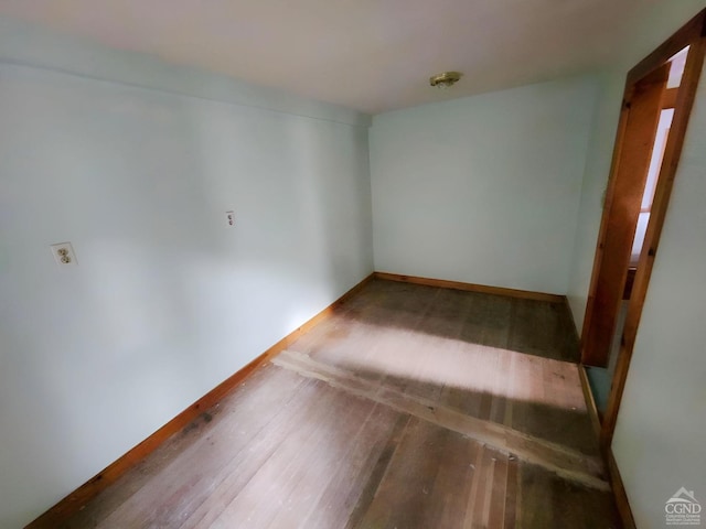 unfurnished room featuring baseboards and hardwood / wood-style flooring