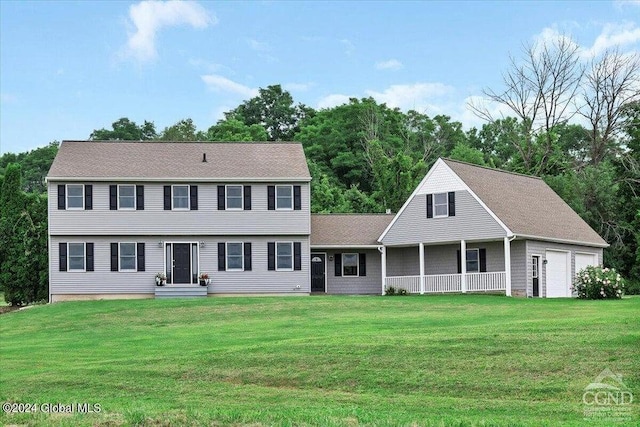 colonial inspired home with a garage and a front lawn