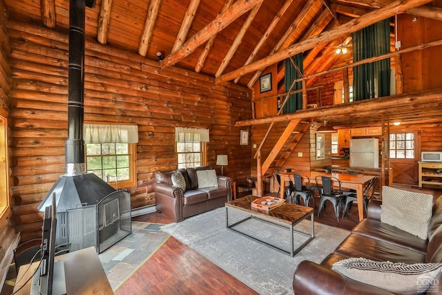 living room featuring beamed ceiling, a wood stove, high vaulted ceiling, and wooden ceiling