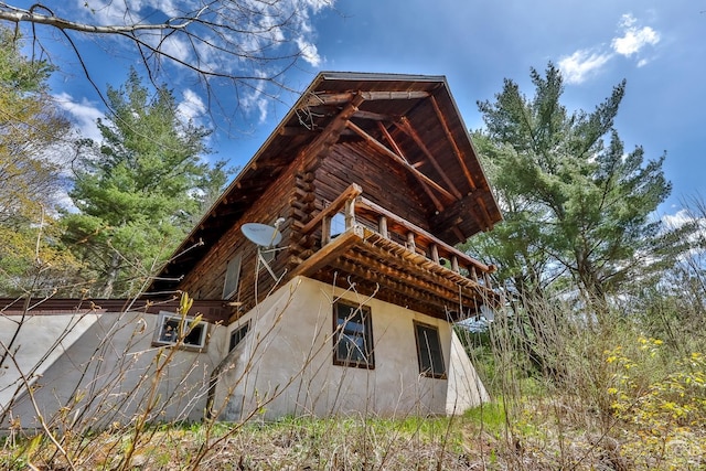 view of property exterior featuring stucco siding and log siding