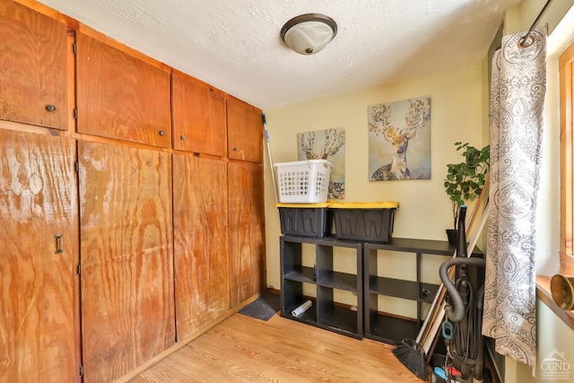 interior space with a textured ceiling and wood finished floors