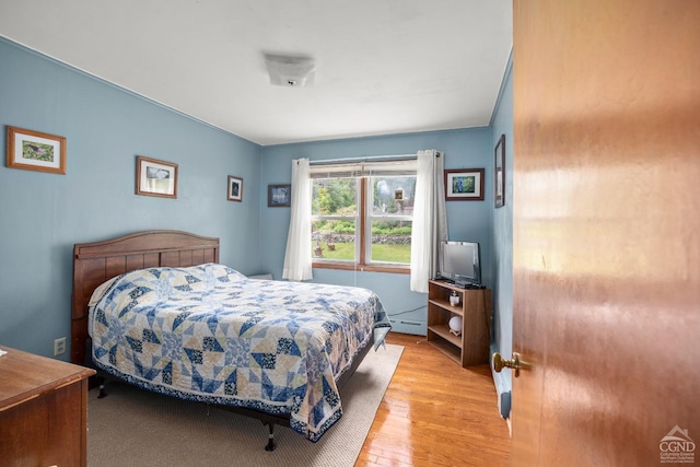 bedroom with light hardwood / wood-style flooring and baseboard heating