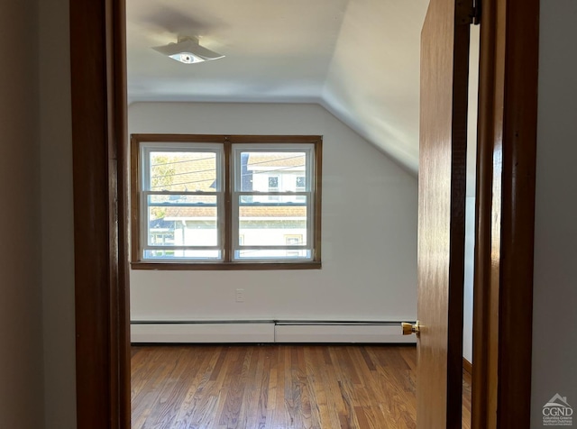 bonus room featuring baseboard heating, hardwood / wood-style floors, and lofted ceiling