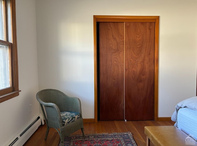 bedroom with a baseboard radiator and light hardwood / wood-style floors