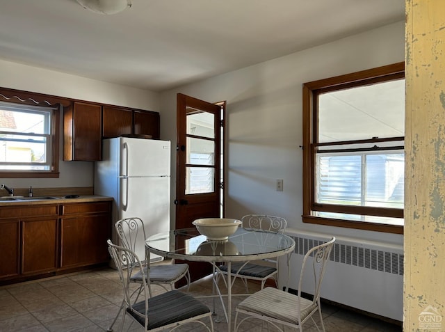 kitchen featuring radiator heating unit, white refrigerator, and sink