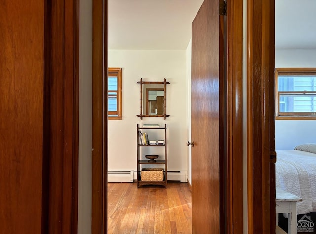 hall featuring light wood-type flooring and baseboard heating