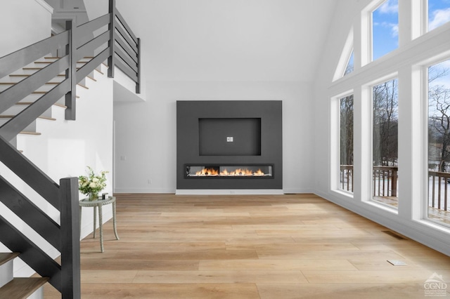 living room with light hardwood / wood-style floors and a high ceiling