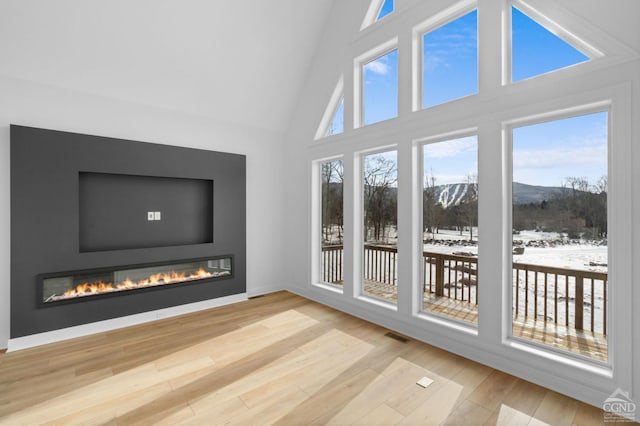 unfurnished sunroom featuring lofted ceiling and a mountain view