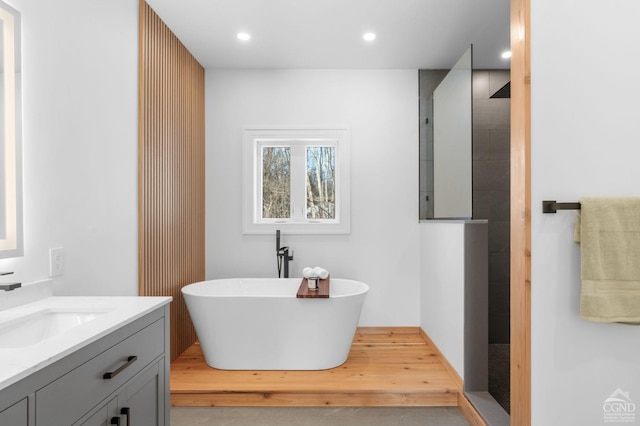 bathroom featuring vanity and independent shower and bath