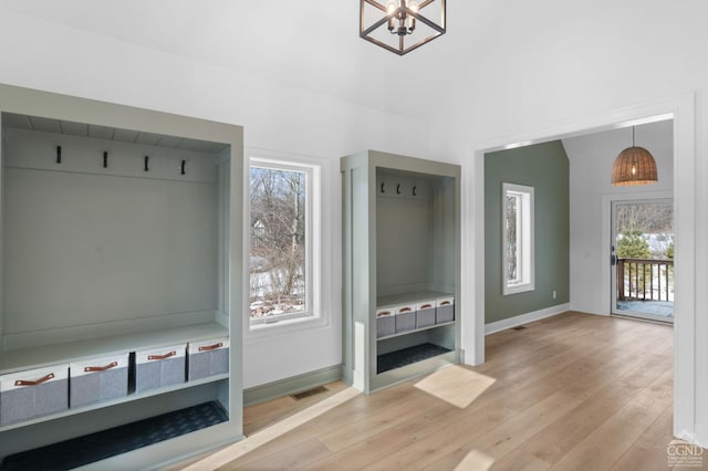 mudroom with light hardwood / wood-style flooring and a notable chandelier