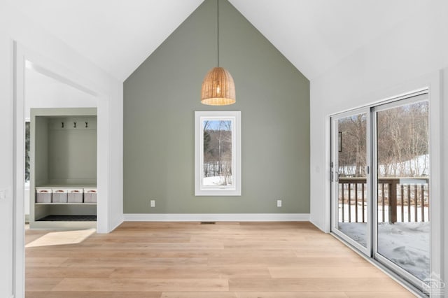 interior space featuring high vaulted ceiling and light hardwood / wood-style flooring