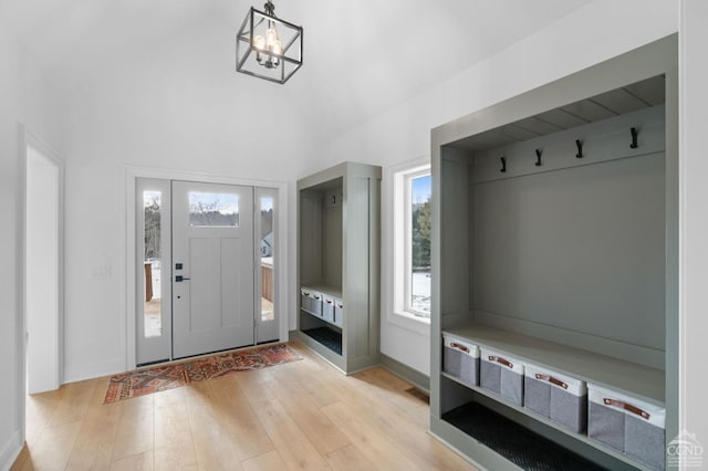 mudroom featuring a notable chandelier and light wood-type flooring