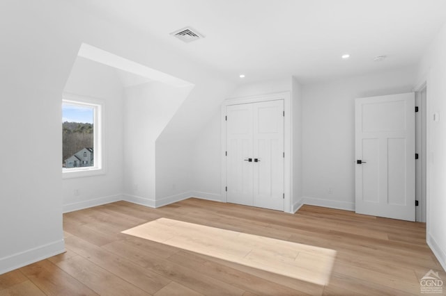 bonus room featuring vaulted ceiling and light wood-type flooring