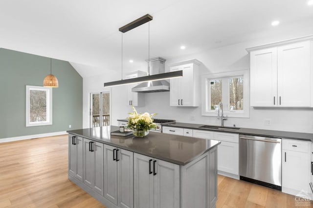 kitchen featuring pendant lighting, sink, white cabinetry, light hardwood / wood-style floors, and stainless steel dishwasher