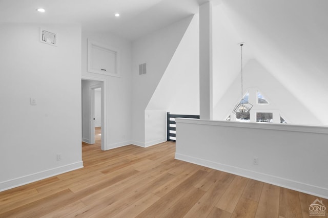 unfurnished living room featuring lofted ceiling and light hardwood / wood-style flooring