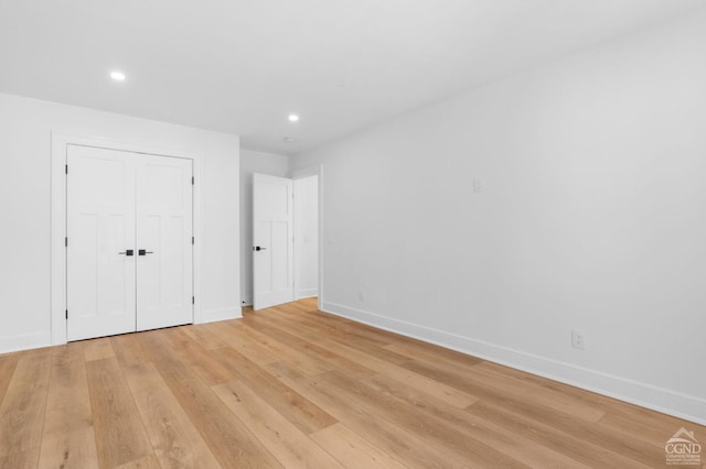 unfurnished bedroom with light wood-type flooring and a closet