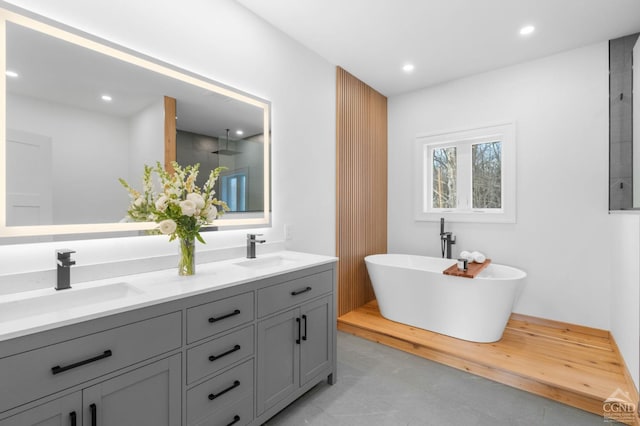 bathroom with a washtub and vanity