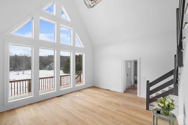 interior space featuring high vaulted ceiling and light hardwood / wood-style floors