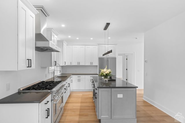 kitchen featuring appliances with stainless steel finishes, decorative light fixtures, a center island, and white cabinets